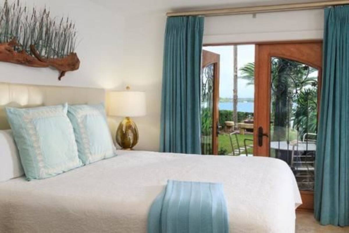 Camera d'albergo con un letto, una lampada, un elemento decorativo a parete e vista sull'esterno.