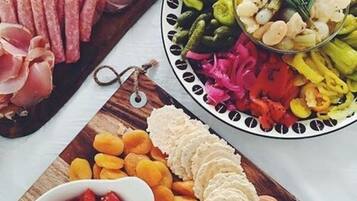 A charcuterie board with various meats, cheeses, and fruits.