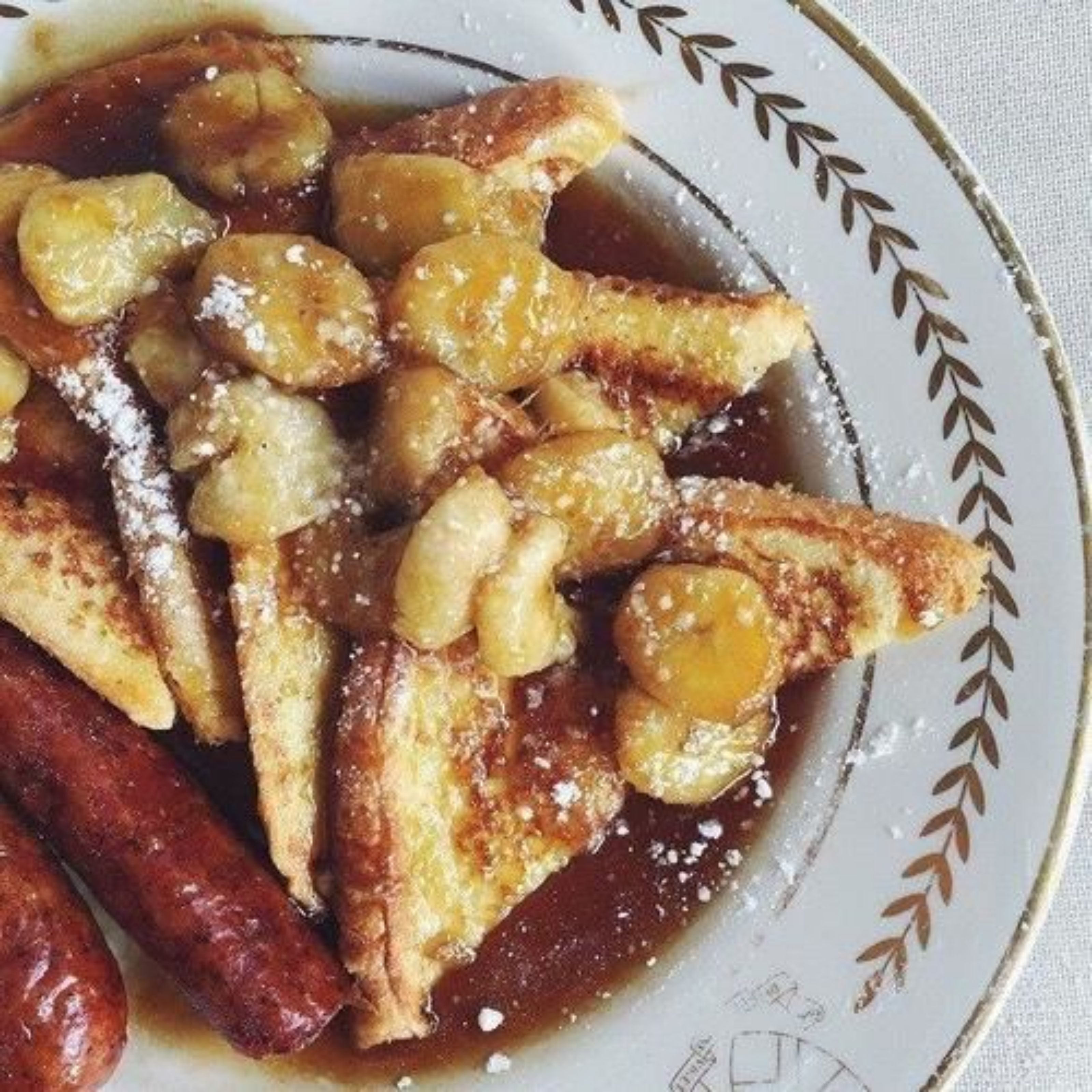 Una porzione di fette di pane fritte con banane e zucchero a velo.