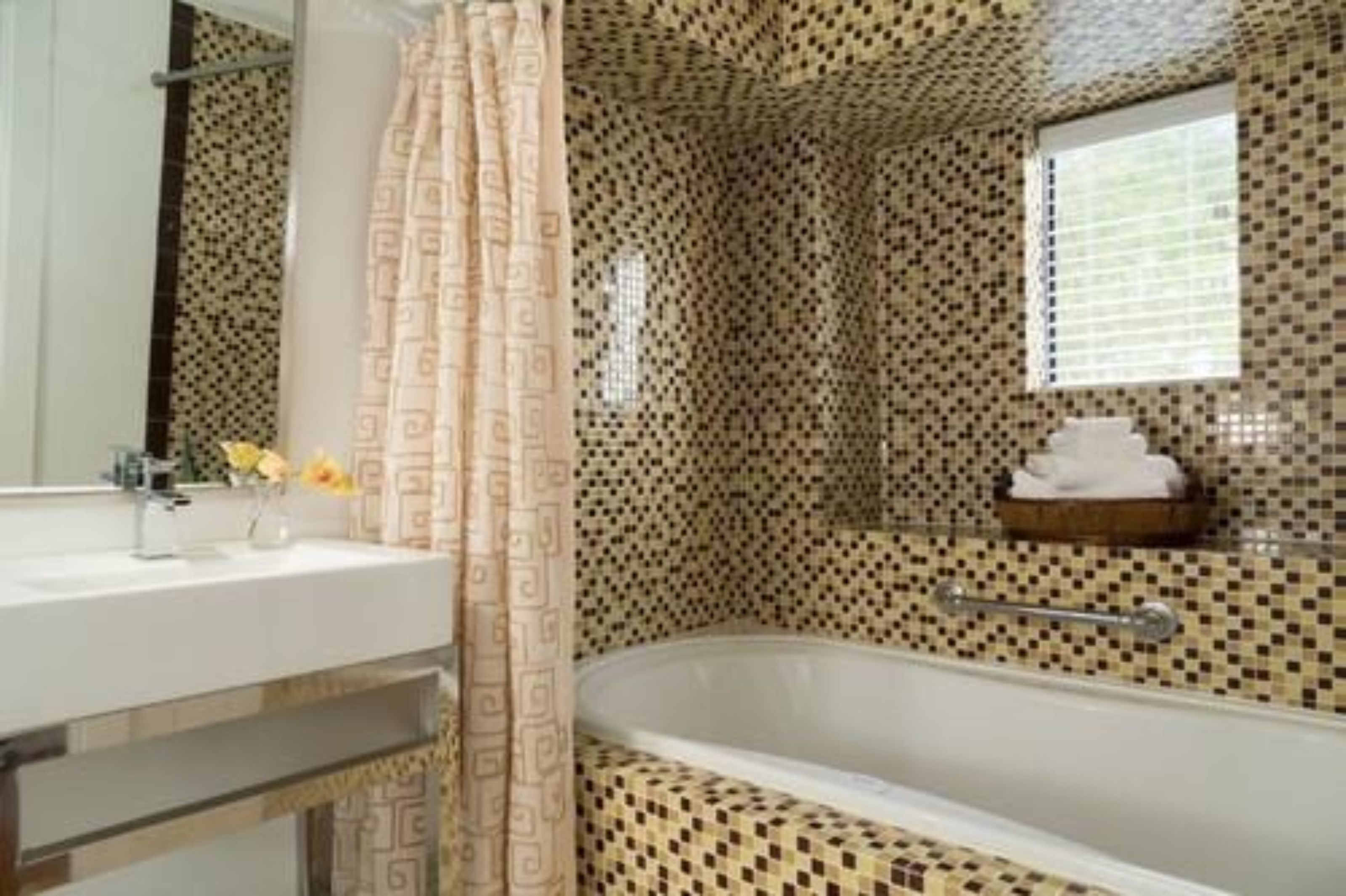 A bathroom with a bathtub, a sink, and a mirror.