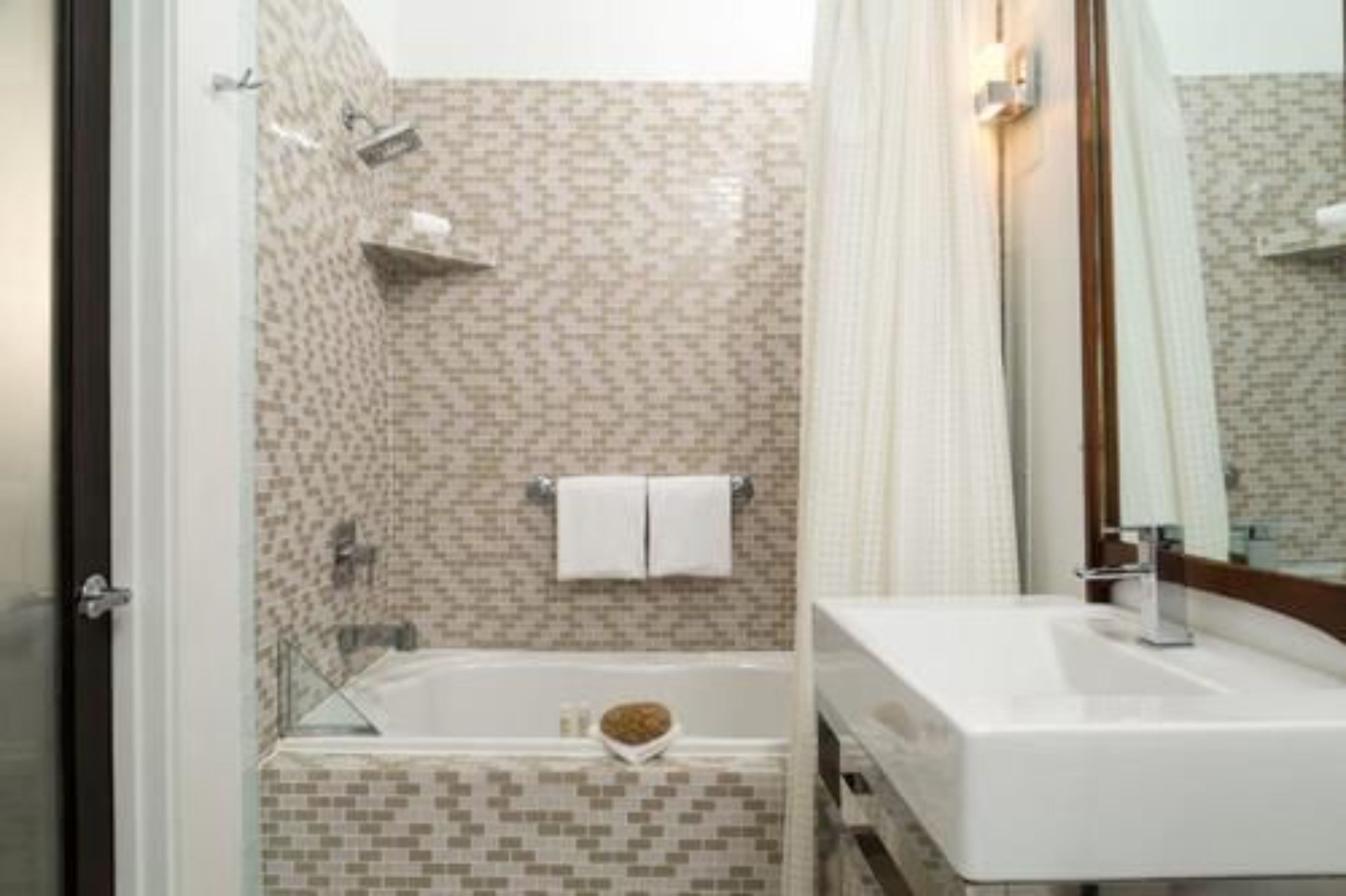 Une salle de bain avec une douche à parois de verre, une baignoire et un lavabo avec un miroir.