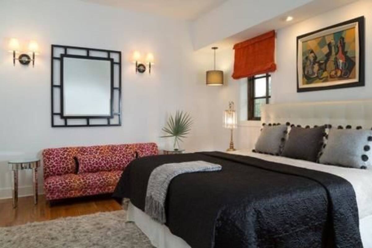 Una camera da letto con un letto, un divano, uno specchio e luci a parete.
