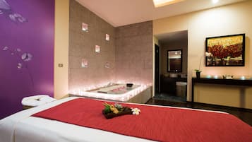 Una moderna spa con un grande letto, una poltrona massaggiante, pavimento riscaldato e lettino per massaggi a parete.