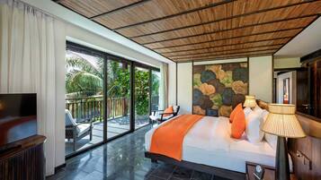 A spacious bedroom with a large bed, a TV, and a balcony with outdoor seating.