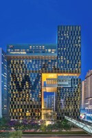 A modern high-rise building with a distinctive geometric facade, large windows, and a prominent entrance area.