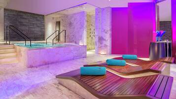 A modern spa area with a hot tub, wooden seating, and a marble floor.