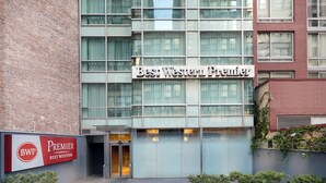 A hotel entrance with a sign reading "Best Western Premier" and a smaller sign for "Premier Best Western." - Best Western Premier Herald Square (New York)