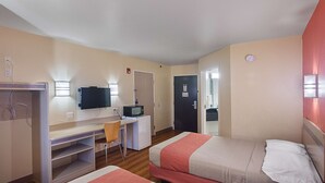 A hotel room with two beds, a desk with a chair, a television, and a microwave. - Motel 6 Terrell, TX (Terrell)