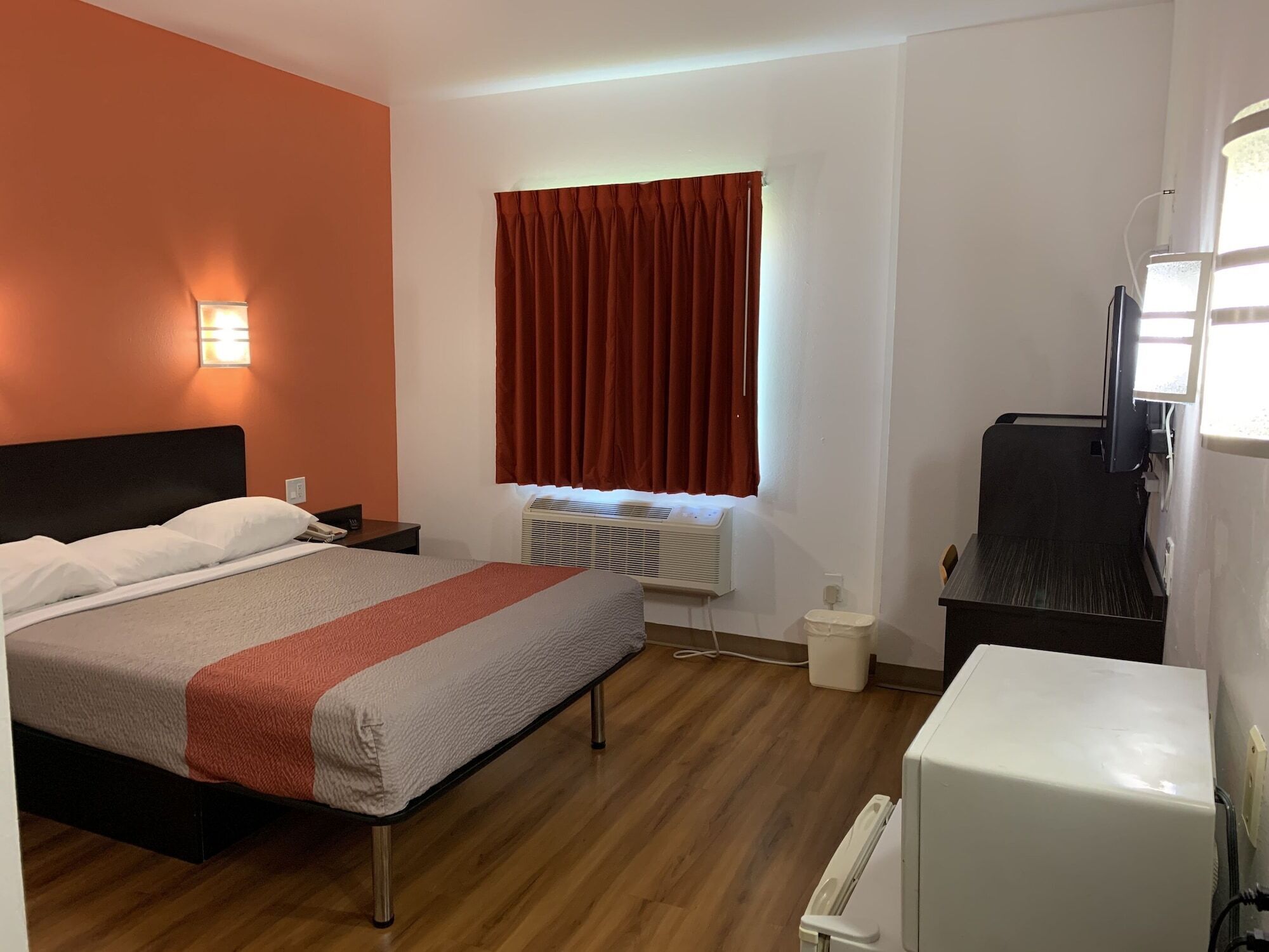 Une chambre d’hôtel équipée d’un lit, d’un bureau, d’une chaise, d’un radiateur et d’une télévision.