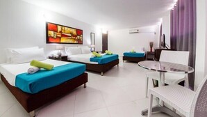Habitación de hotel con dos camas, una mesita y una silla.