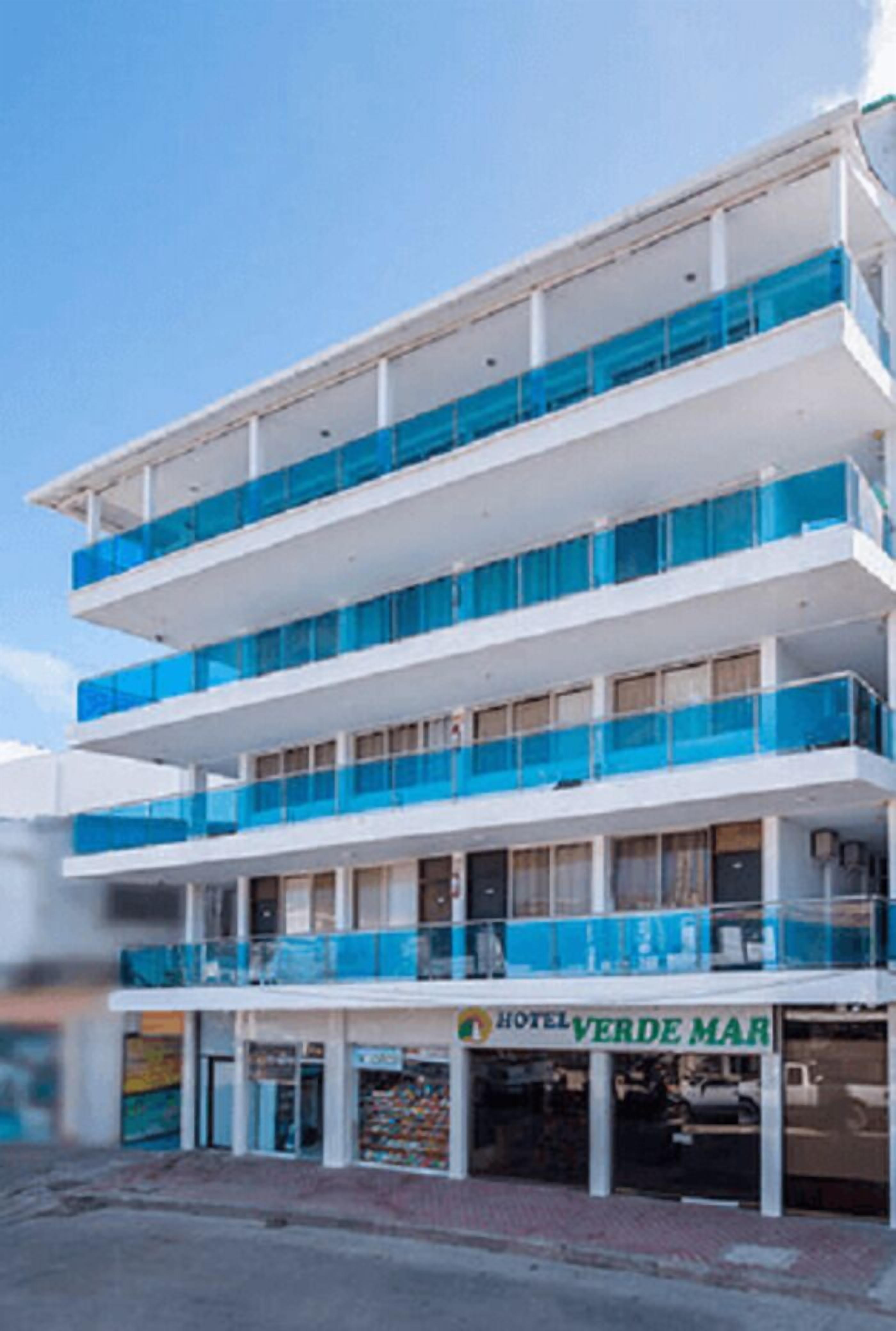 A multi-story hotel with balconies and a sign reading "HOTEL VERDE MAR".