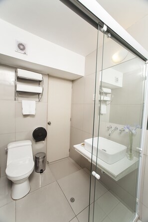 A modern bathroom with a toilet, bidet, and glass-enclosed shower. - El Angolo Lima (Lima)