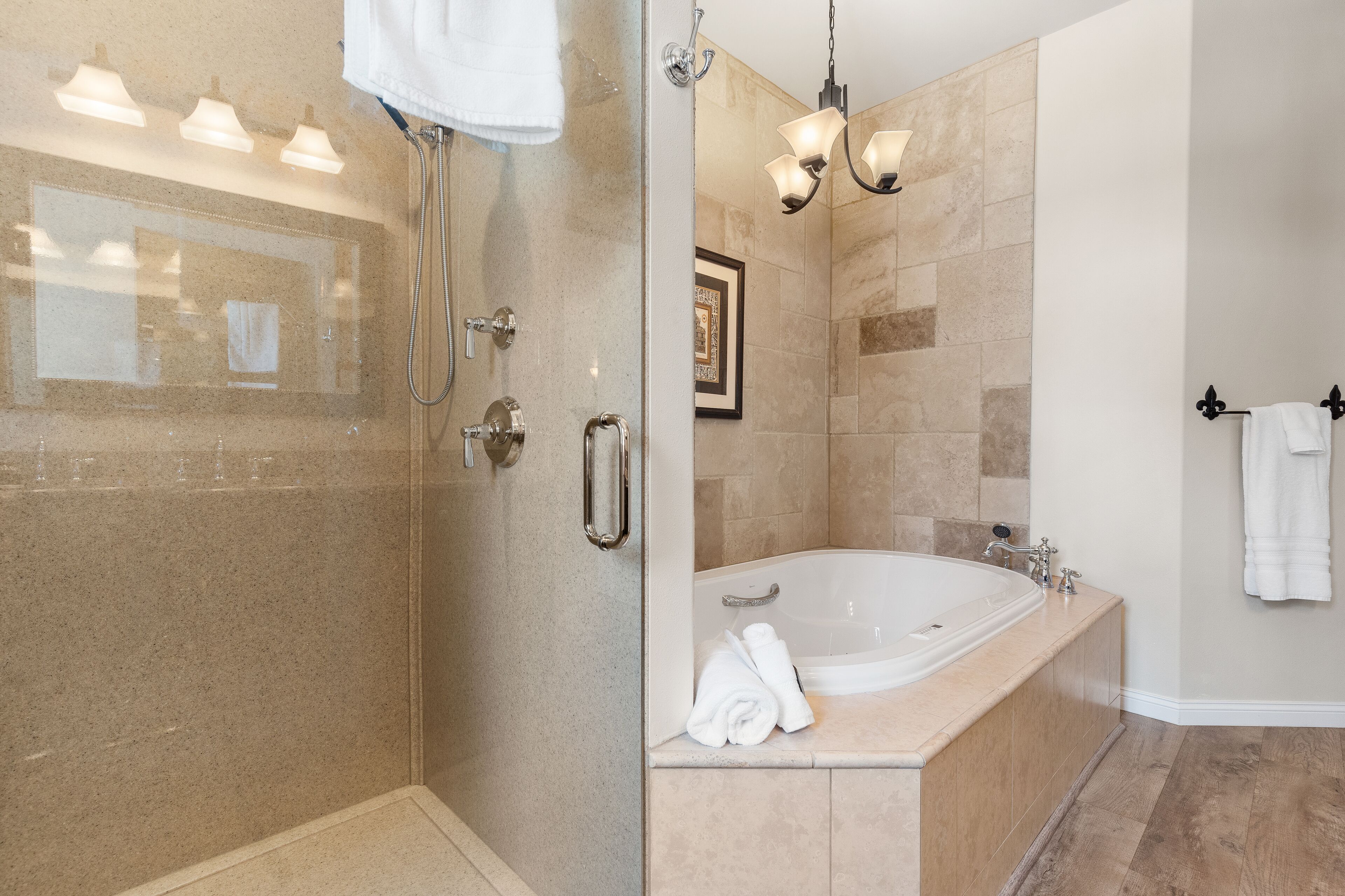 Une salle de bain moderne dotée d’une douche à parois de verre, d’une baignoire sur pieds et d’un meuble-lavabo avec un miroir.