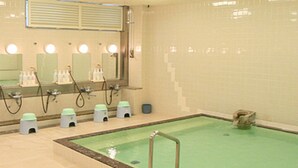 Une salle de bain avec une piscine, des lavabos, des miroirs et des articles de toilette.
