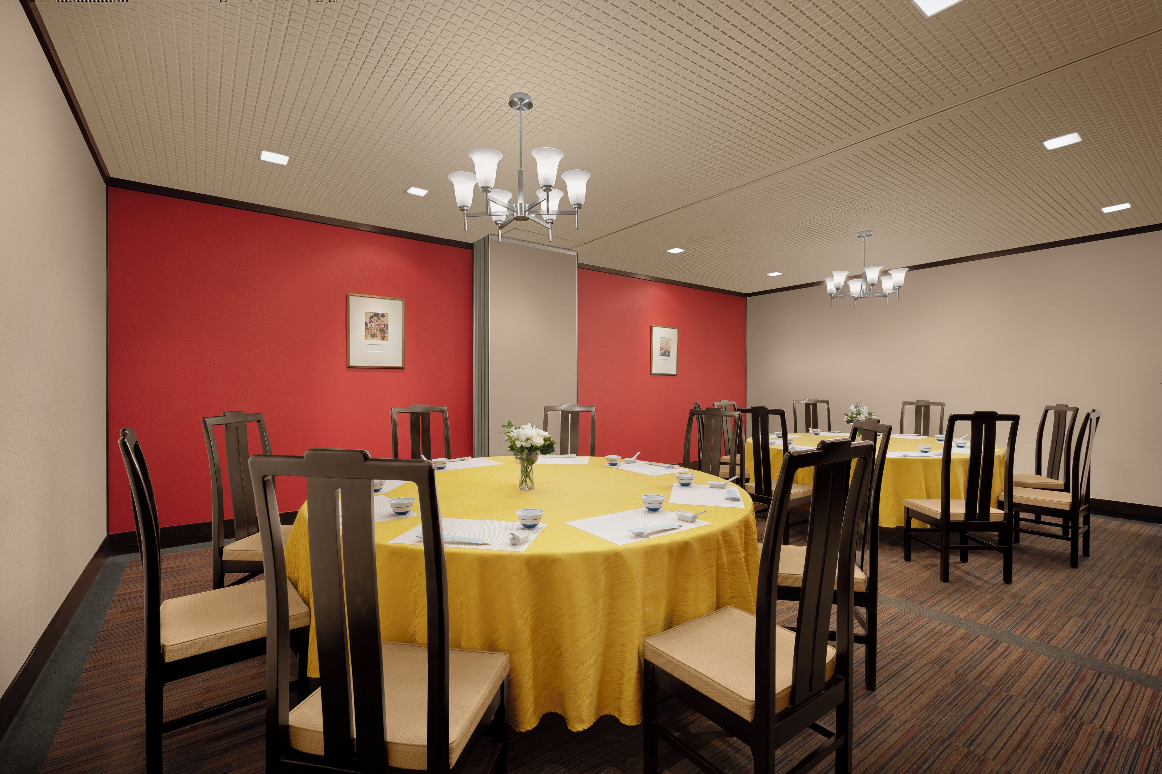 A conference room with round tables, chairs, and a chandelier.