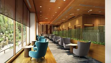 A modern interior with a long corridor, seating area, and a view of greenery outside.