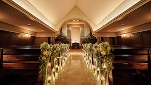 An aisle with pews, a central aisle with floral arrangements and candles, and a view of the altar at the end. - ANA Crowne Plaza Kochi by IHG (Kochi)