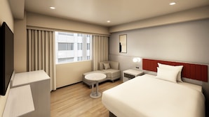 Een hotelkamer met een bed, nachtkastje, lamp en uitzicht op de stad.