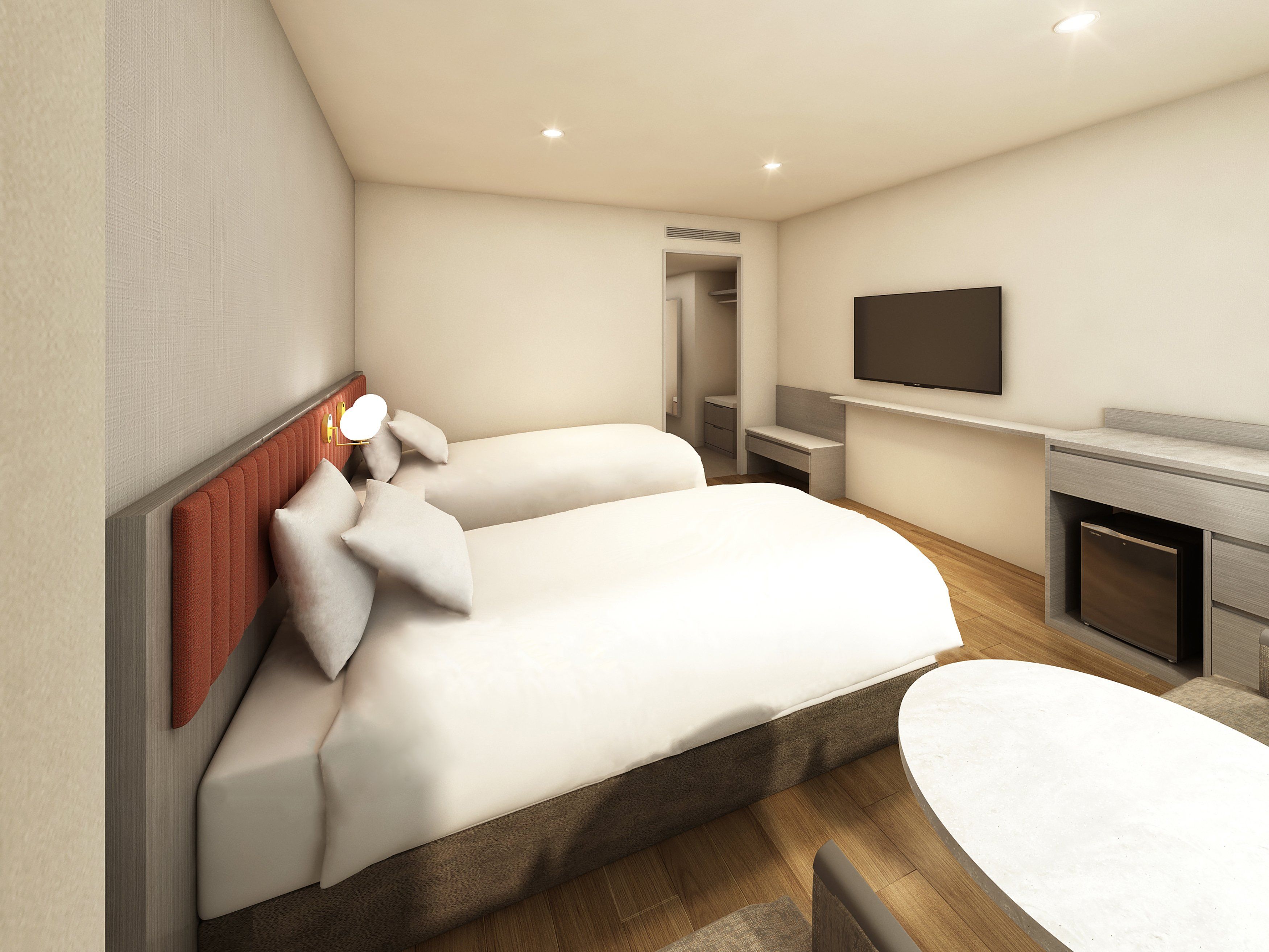 A modern hotel room with a bed, bedside table, TV, and a small desk area.