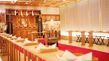 A traditional Japanese-style room with tatami mats, low tables, and a red carpet.