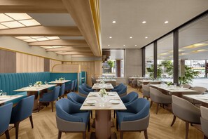 Un intérieur de restaurant moderne, avec des banquettes, des tables et des chaises.