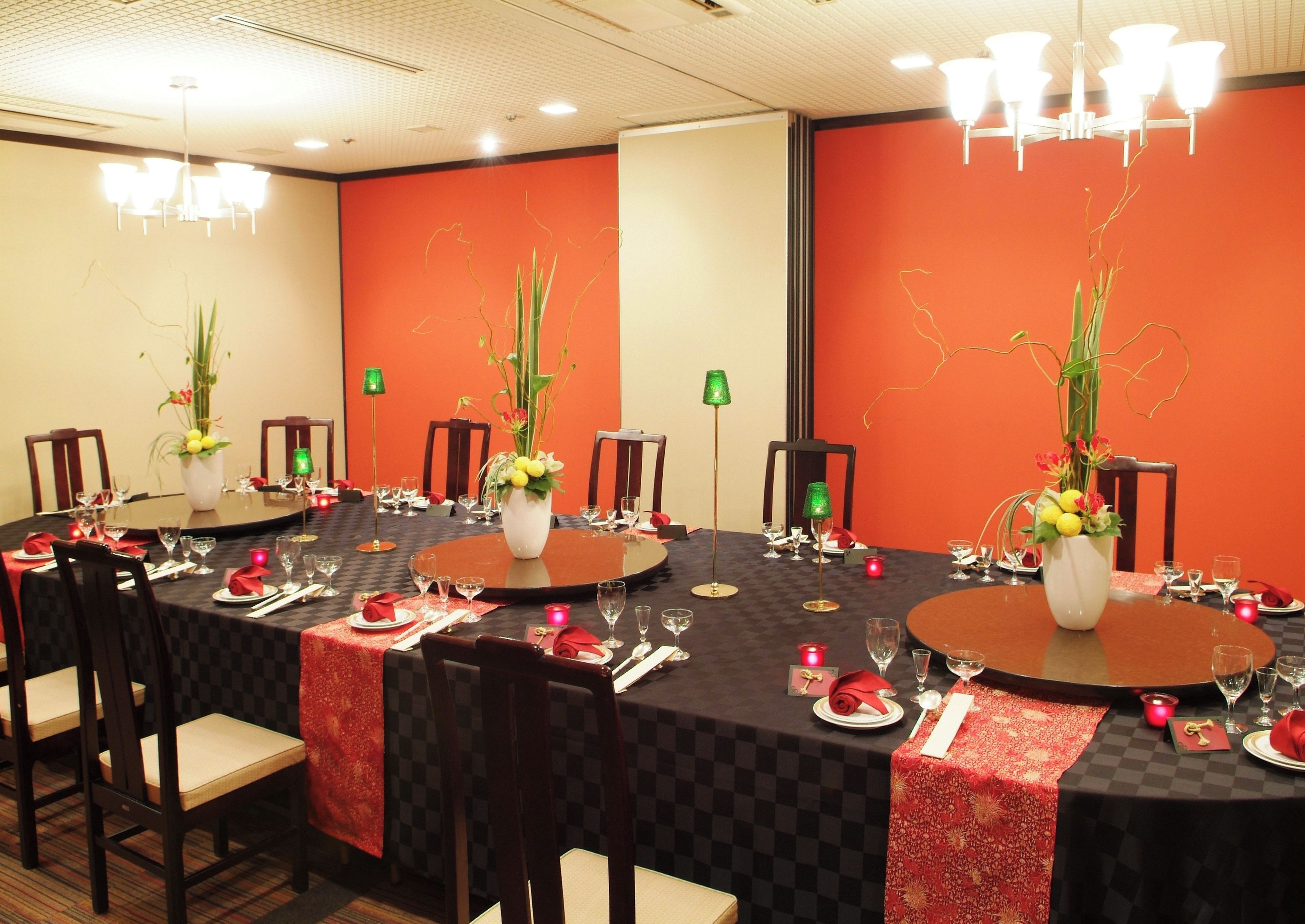A conference room with round tables, chairs, and floral centerpieces.