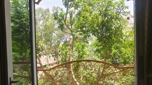 An open door with a view of a balcony, a tiled floor, and a metal railing. - Ray of Maya Hotel (Agra)