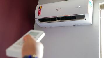 A white air conditioning unit with a red ribbon on the top left corner, labeled "Springer Midea."