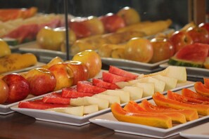 Un bufé con diversas frutas dispuestas en platos.