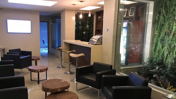 Un hall d’entrée avec des espaces d’attente, un comptoir de réception et une grande fenêtre donnant sur un immeuble.