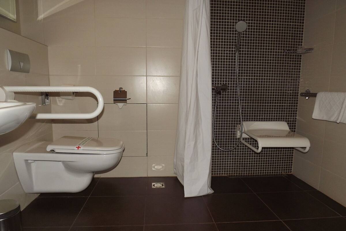 Un baño con inodoro, lavamanos y ducha.