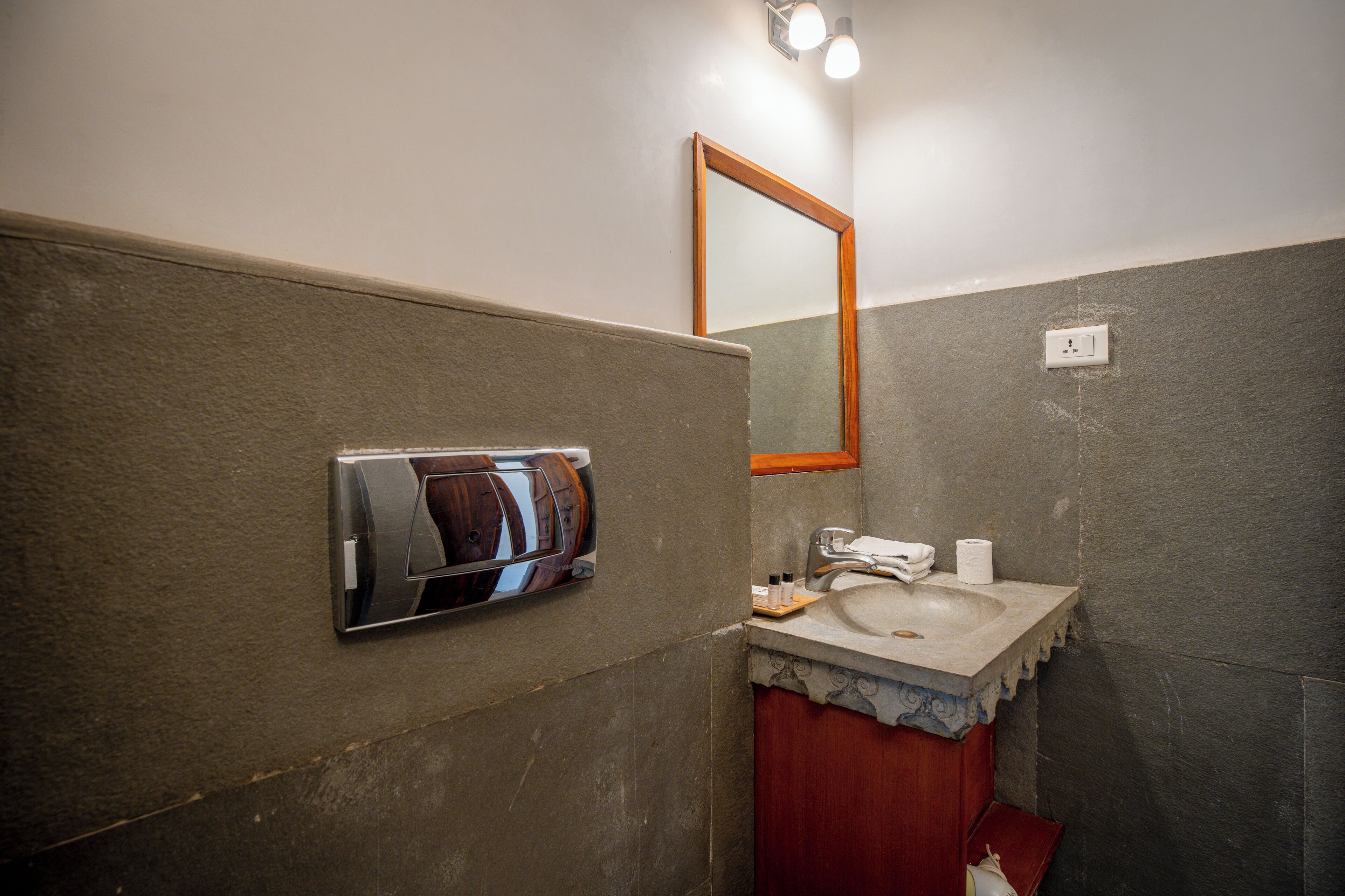 A bathroom with a sink, mirror, and towel dispenser.