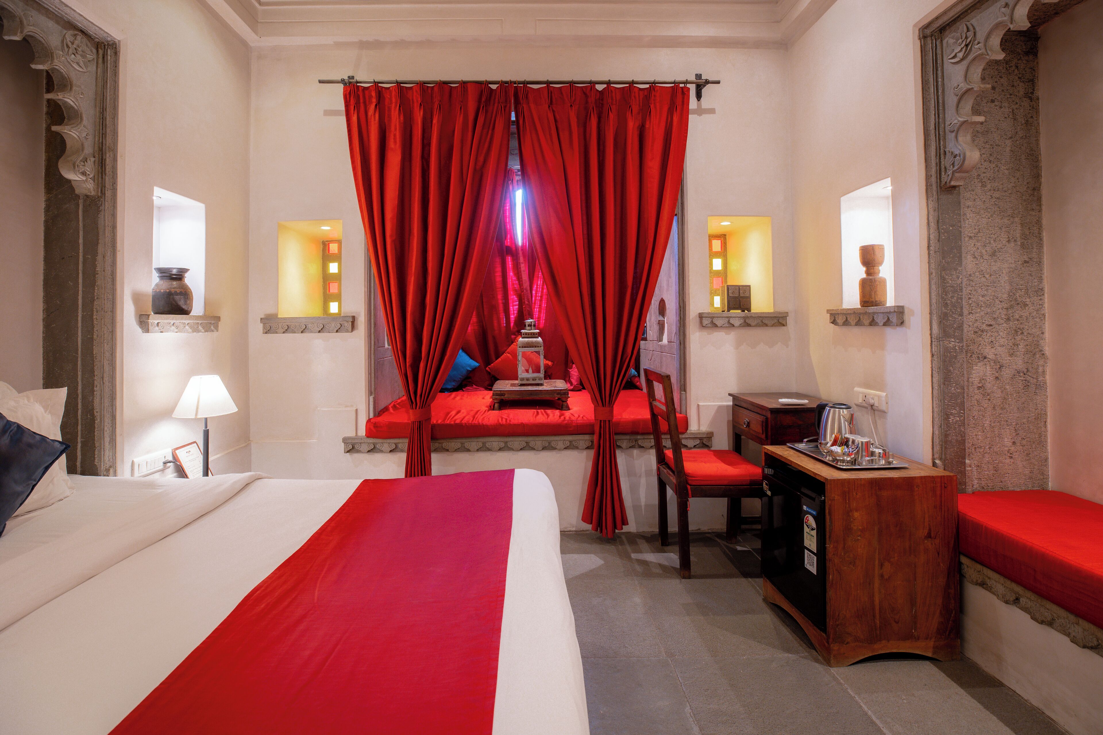 Une chambre d’hôtel avec un grand lit, un bureau, une chaise et une petite table.