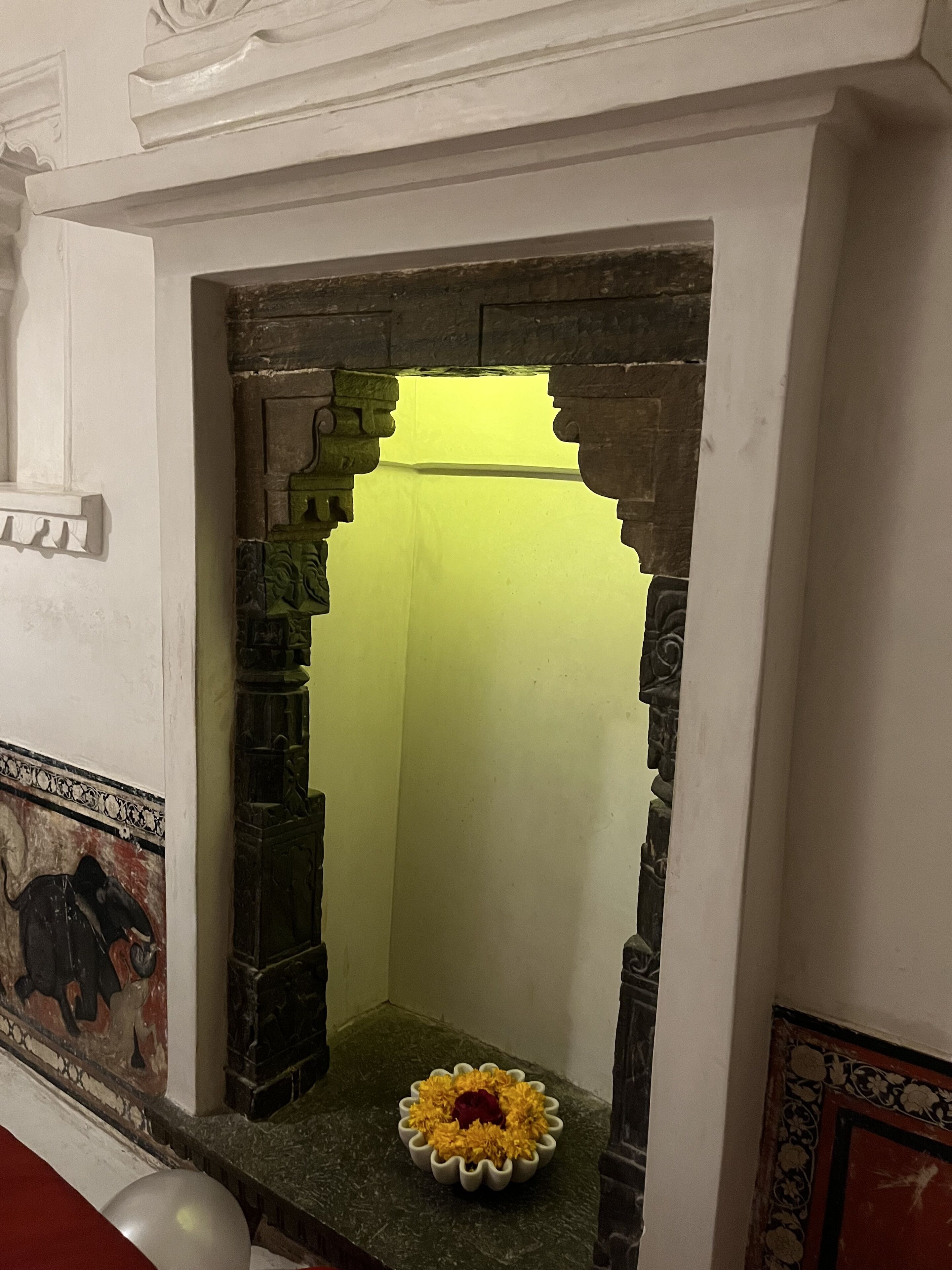 A small shrine with a flower arrangement and a statue.