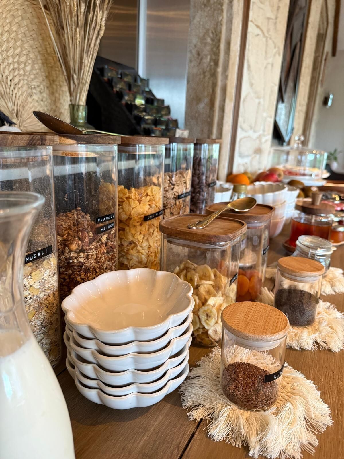 Un montaje tipo buffet con diferentes alimentos en recipientes y cuencos de vidrio.