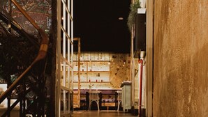 Una escalera conduce a una habitación con un muro cubierto de grafitis y un ventanal.