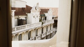 Vista desde una ventana de un edificio con balcones y fachada blanca.