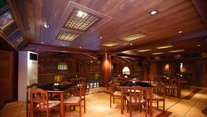 Un restaurante con mobiliario de madera y suelo de baldosas.