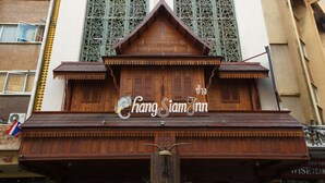 Un edificio tradicional de madera con un letrero que dice "Chang Siam Inn".