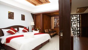 Un dormitorio amplio con una cama grande, muebles de madera y un techo decorativo.