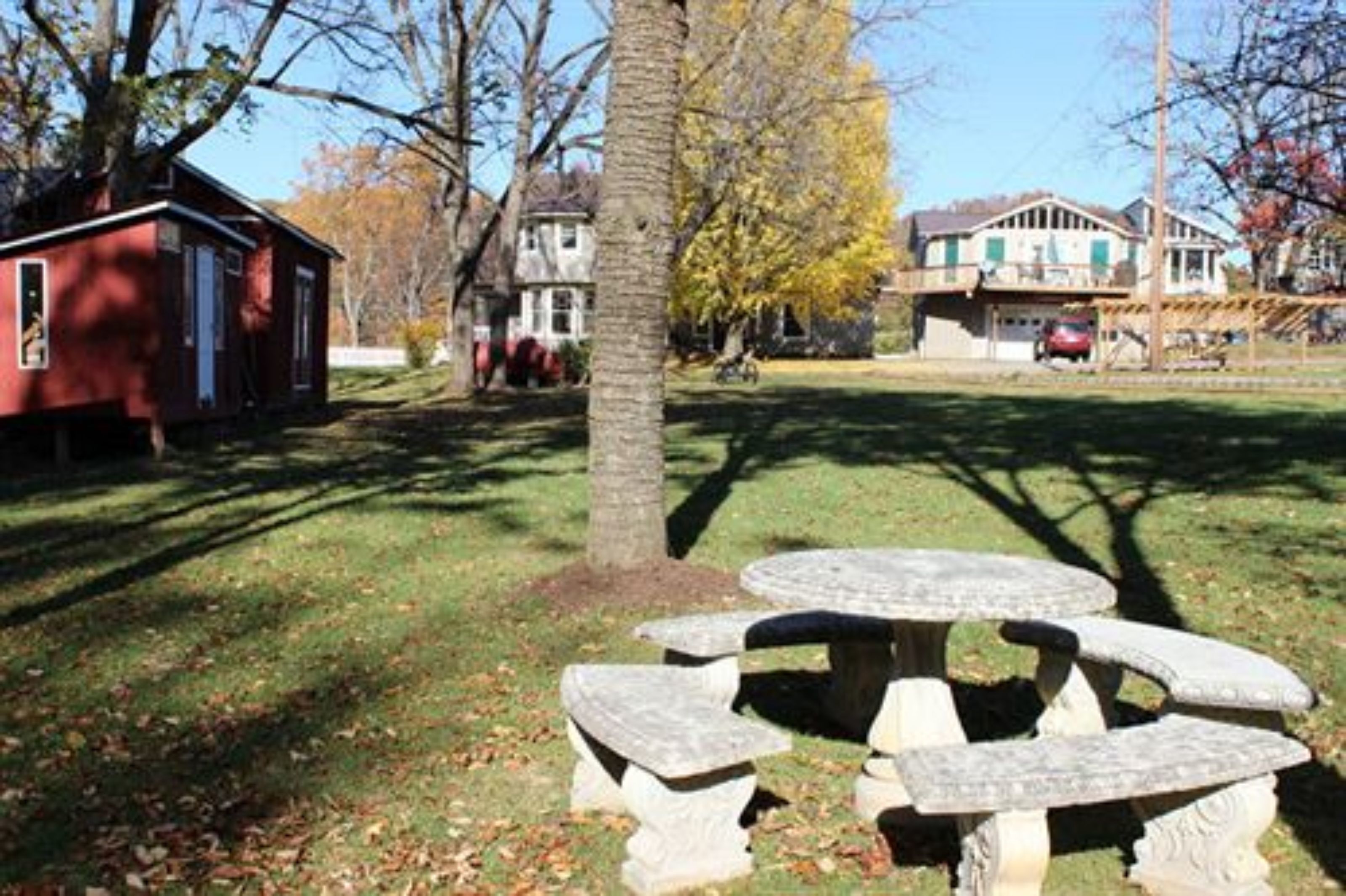 A picnic table with four benches in a park setting.