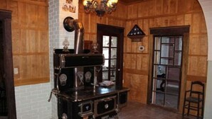 A room with wooden paneled walls, a vintage stove, and a chandelier. - Millsap-baker Estate (Damascus)