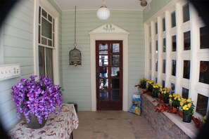 A porch with a door, a birdcage, and potted plants. - Millsap-baker Estate (Damascus)