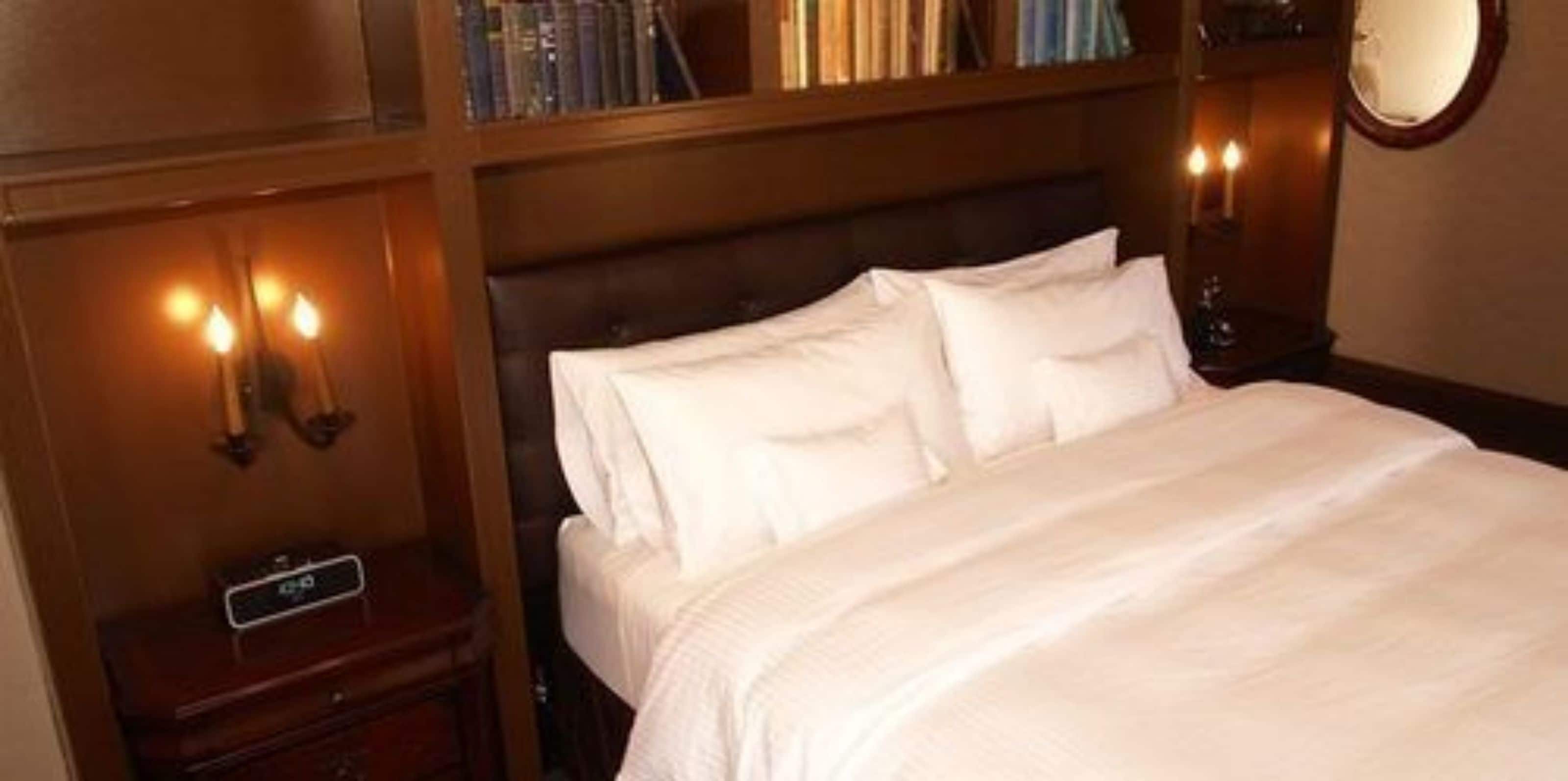 Una cama bien hecha con sábanas blancas en una habitación de hotel.
