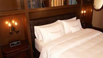 Una cama bien hecha con sábanas blancas en una habitación de hotel.