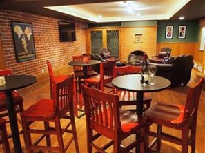 Un restaurante con paredes de ladrillo, mesas de madera y sillas rojas.