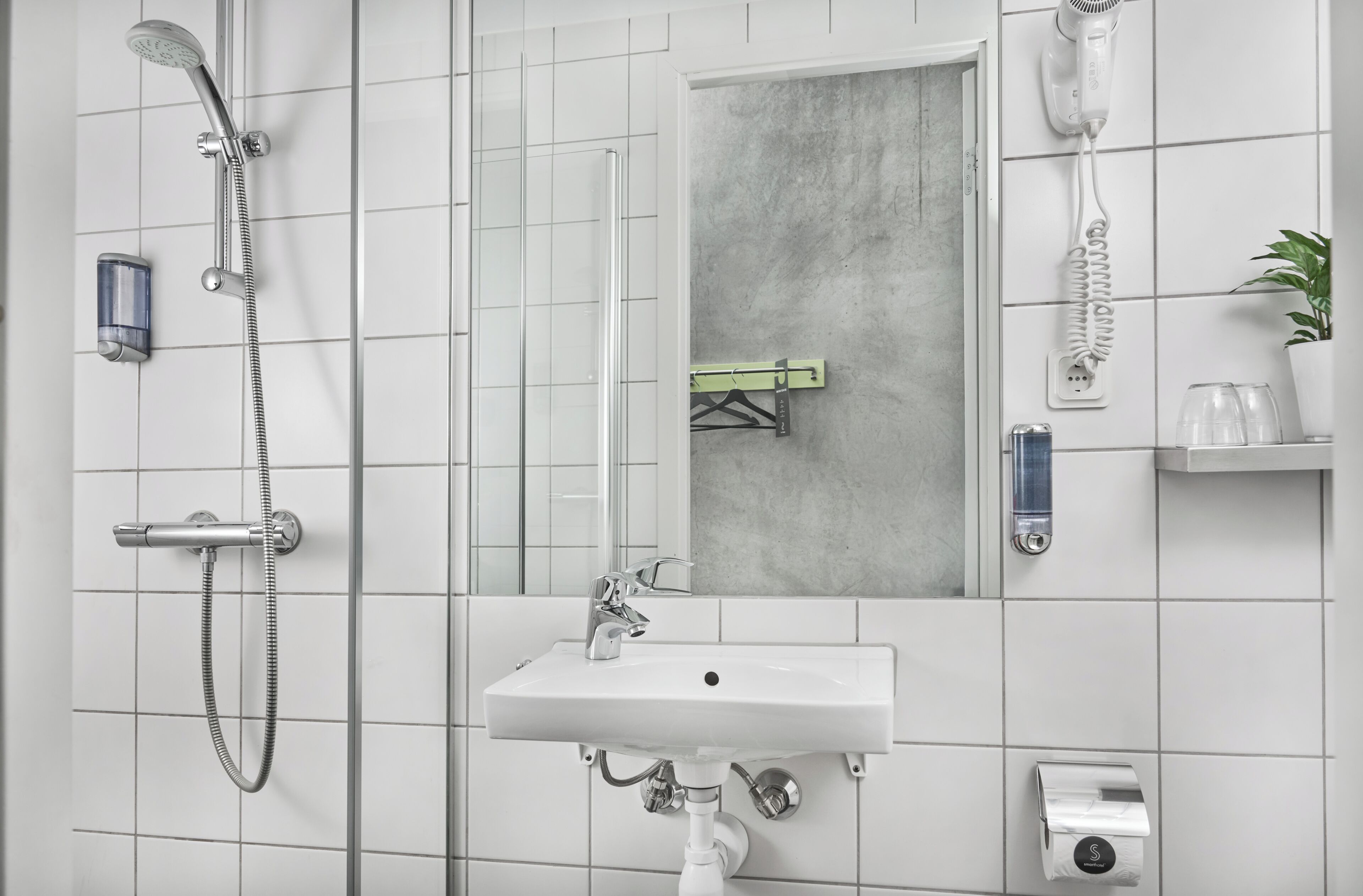 Ein modernes Badezimmer mit Dusche, Waschbecken und Spiegel.