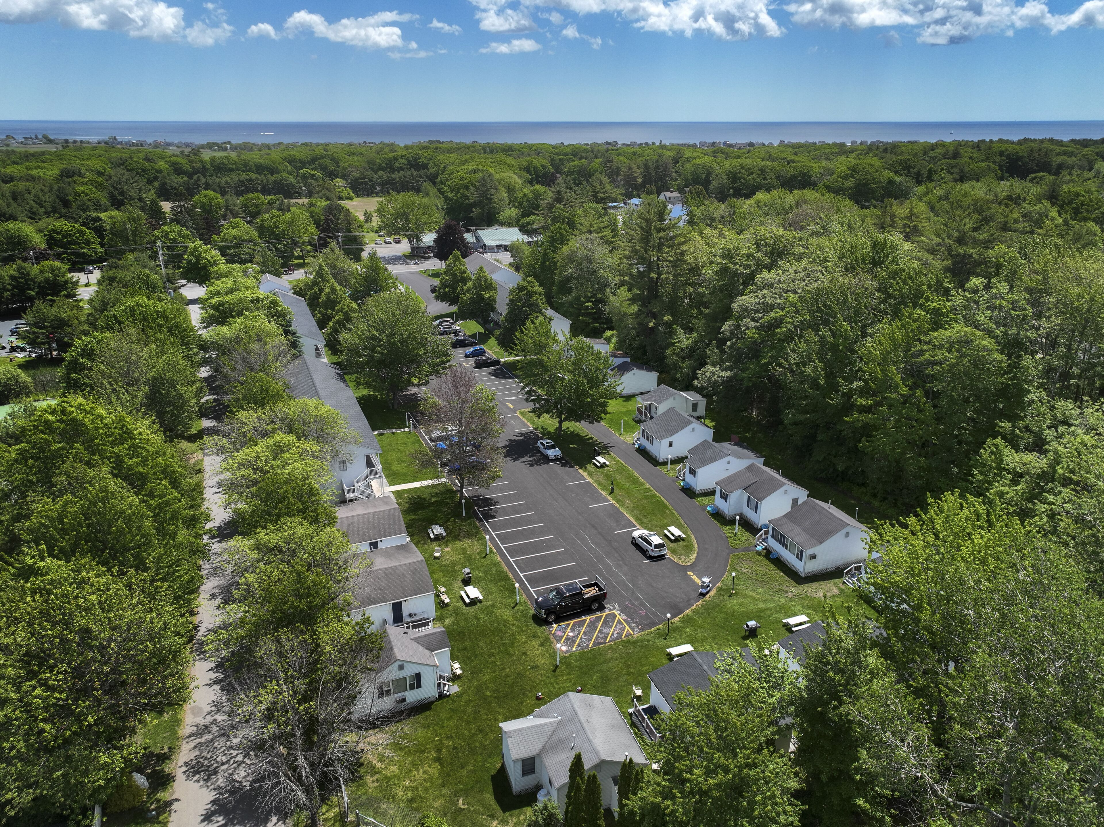 Un quartier résidentiel composé de maisons de plain-pied, doté d’un parking central et offrant une vue sur l’océan.
