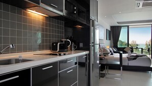A modern kitchen with a built-in oven and microwave, a large sink, and a dining area with a table and chairs.