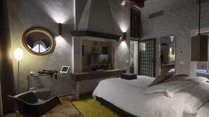 A modern bedroom with a large bed, a desk with a computer, a chair, and a round mirror. - Hotel Corte di Gabriela (Venice)